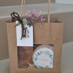 Geschenktasche mit Messerbrett und runder Käse mit Text "Herzlichen Glückwunsch zum Geburtstag"