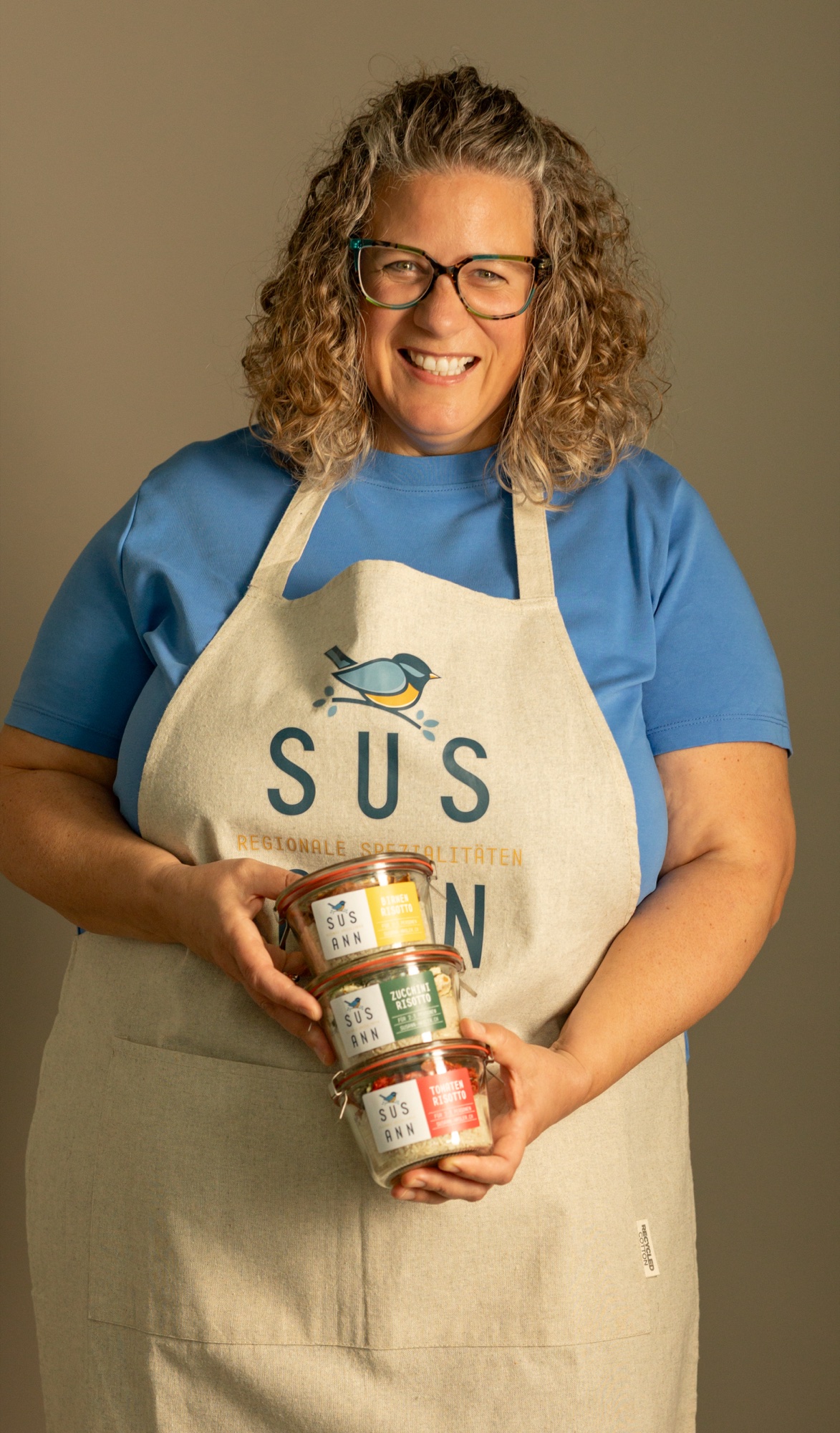 Susann Hasler in der SUS ANN Schürze mit drei Risotto-Gläsern